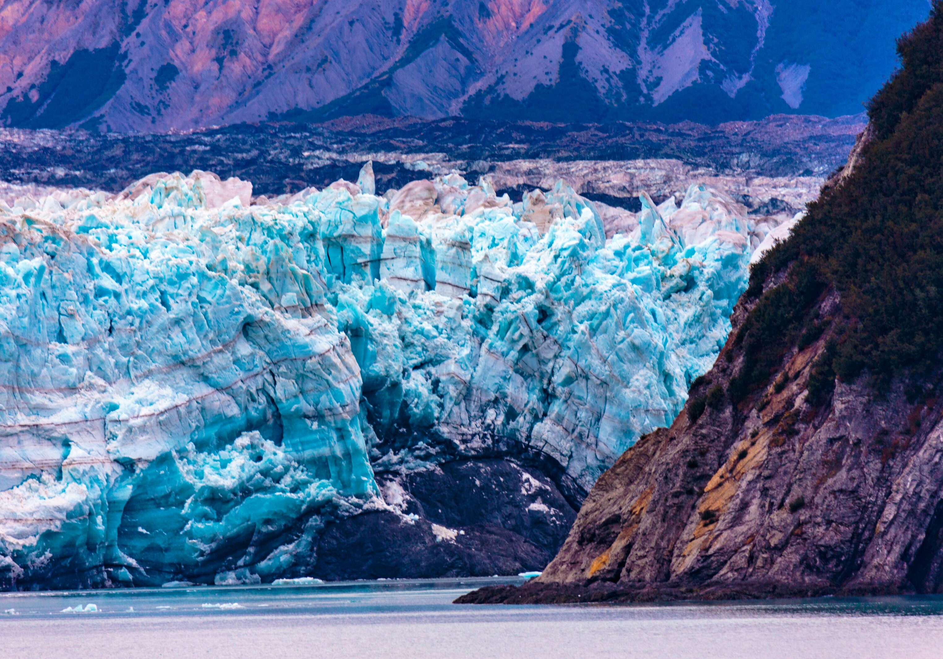 A vibrant blue glacier nestled between rocky cliffs.